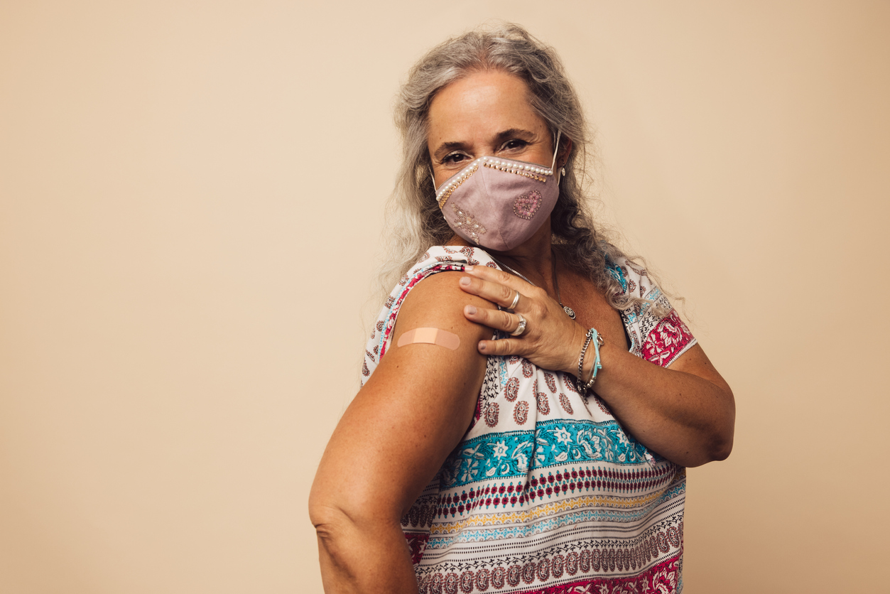 Elderly woman in a mask sporting bandage